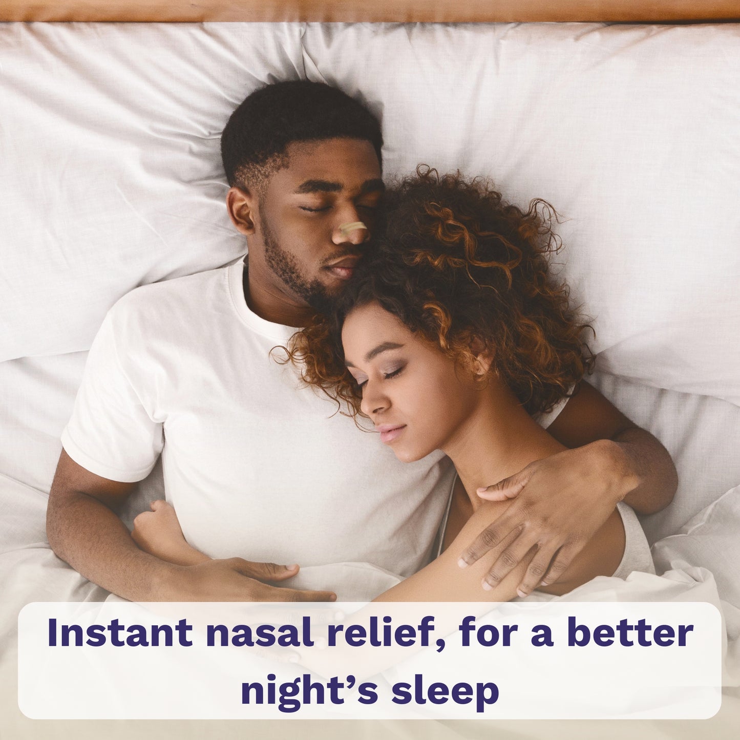 Couple sleeping in bed; man wearing beige nasal strip.